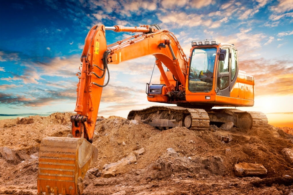 Excavator at a construction site against the setting sun. High quality image.